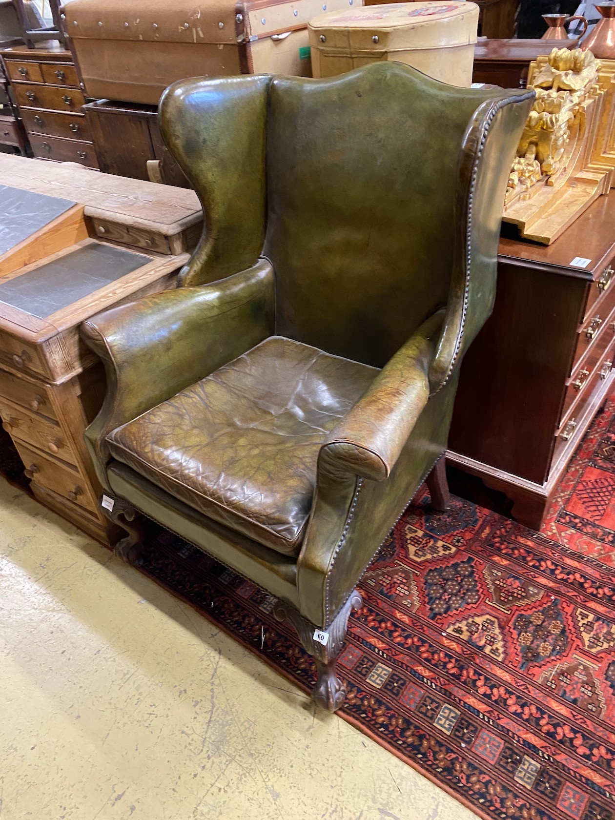 A George III style mahogany and olive green leather upholstered wing armchair, width 79cm, depth 78cm, height 114cm